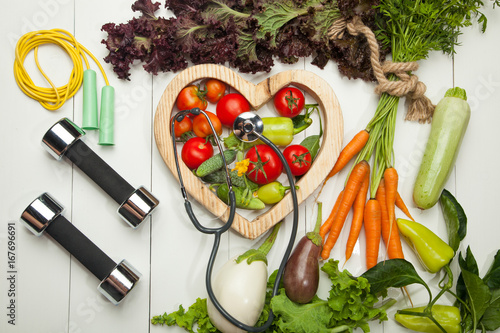 Fresh vegetables. Diet, a healthy lifestyle. Sport, dumbbells and a skipping rope on a white background