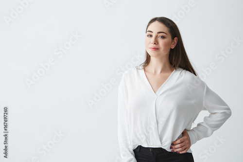 Portrait of young beautiful brunette businesswoman smiling looking at camera posing over white background.