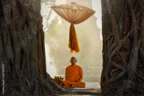 Buddhist monks are sitting samati on temple in mist sunset,Thailand photo