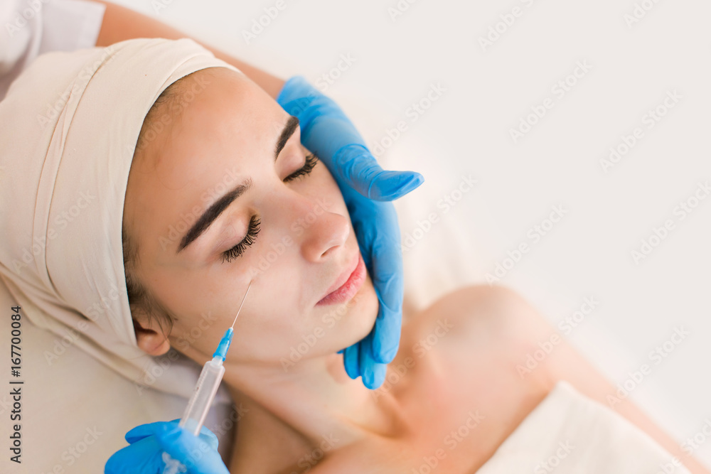 Beautiful woman face getting beauty injections