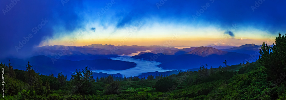 Fototapeta premium Panorama of mountain ridges with clouds and fog in the morning evening time, at sunrise, sunset