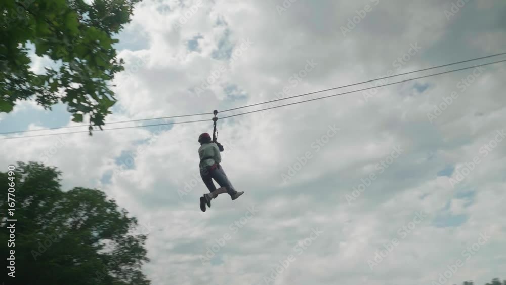 Two people riding on zip line and go straight into tree leaf Two people riding on zip line and go straight into tree leaf