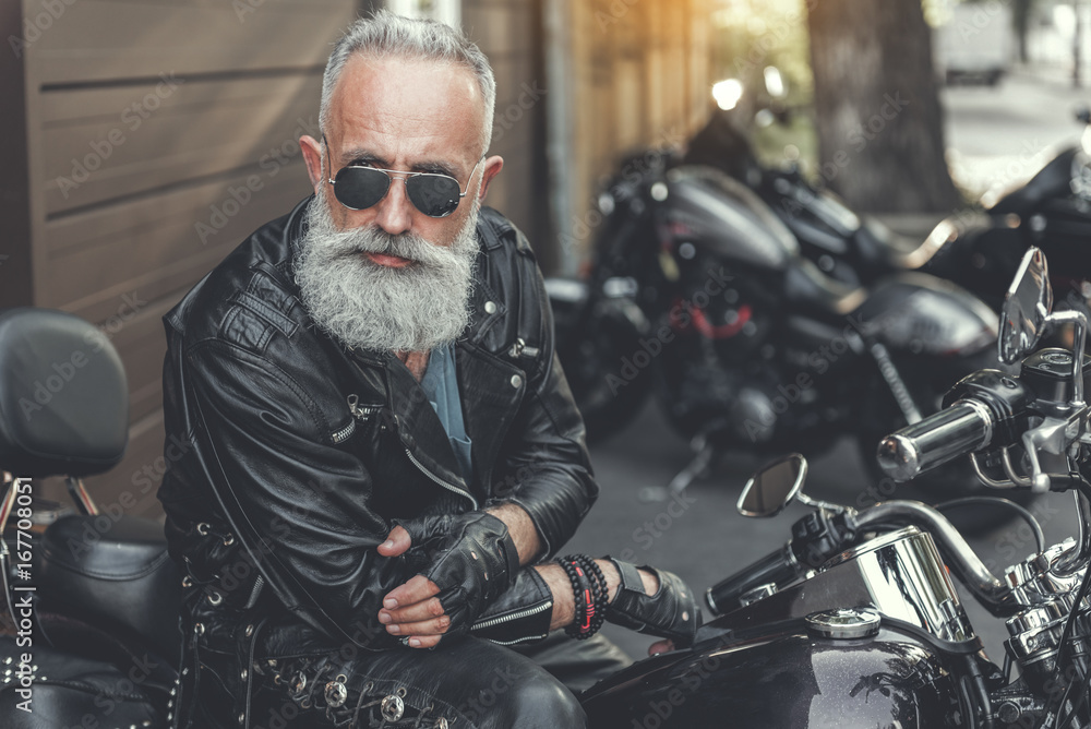 Serious old male person using motorbike