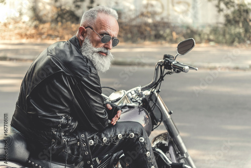 Tela Interested old man ready for riding motorcycle
