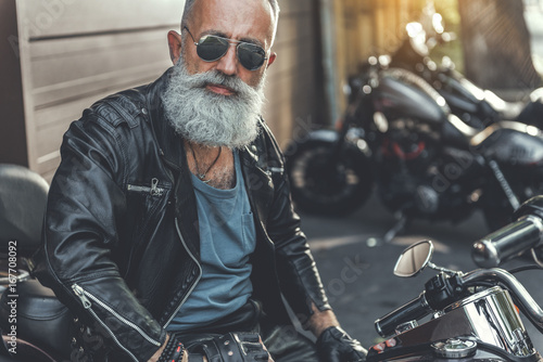 Old male person ready to ride motorbike