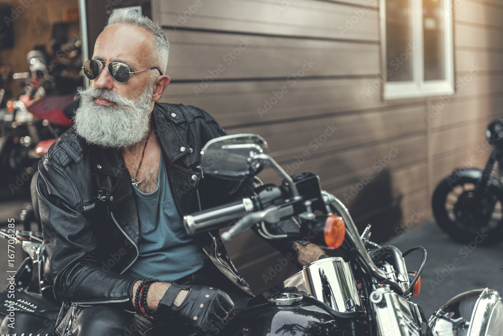 Serious bearded old man on motorbike