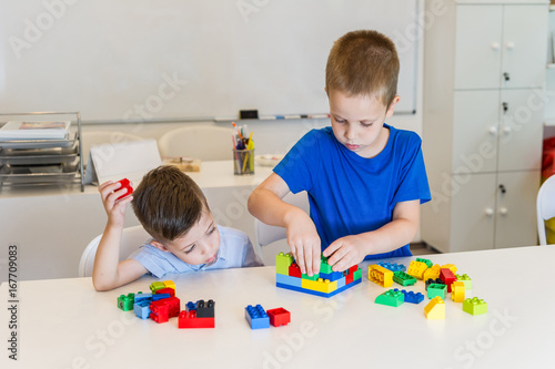 two child boy playing with cubes on the table