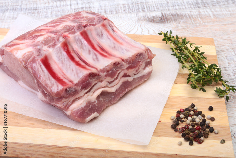 Raw pork chops, spices and rosemary on cutting board. Ready for cooking.