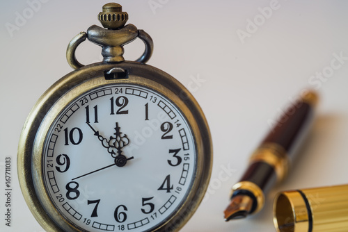 Pocket watch and pen on white