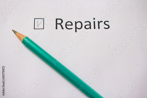 Finish the repair in the house. word REPAIR is written on white paper with tick and gray pencil.