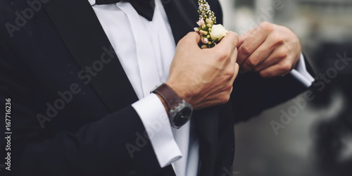 Groom putting his boutonnier on photo