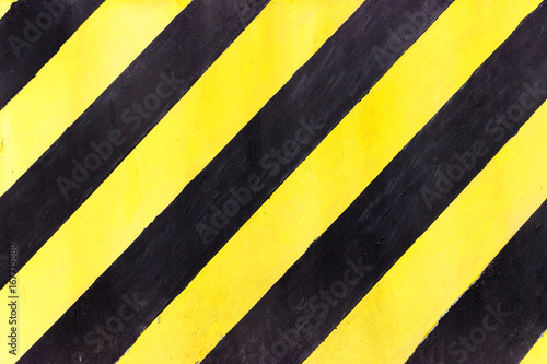 Safety stripes on construction site, Black and yellow Under construction sign over a grunge texture, top view © sosiukin