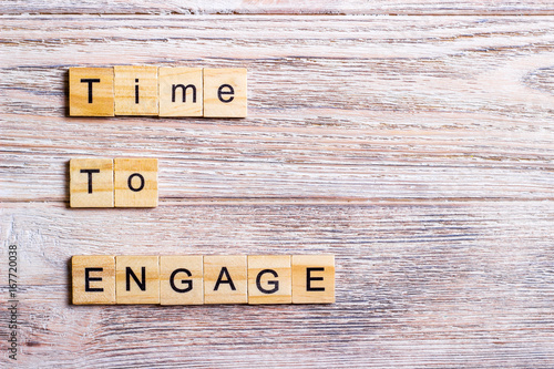 time to engage text on cubes on wooden background