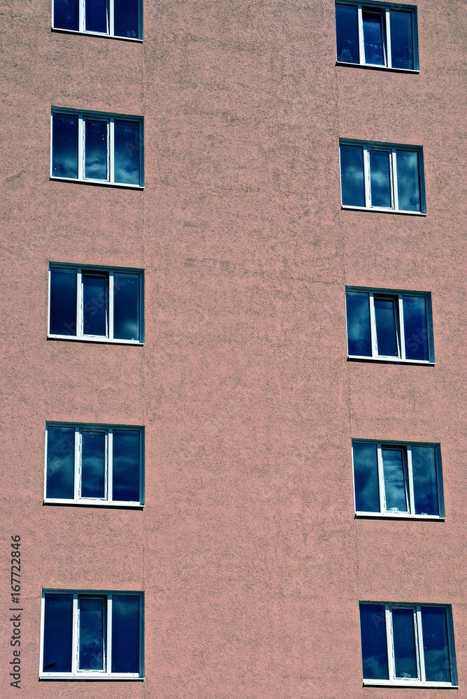 ряд окон на коричневой стене многоэтажного дома