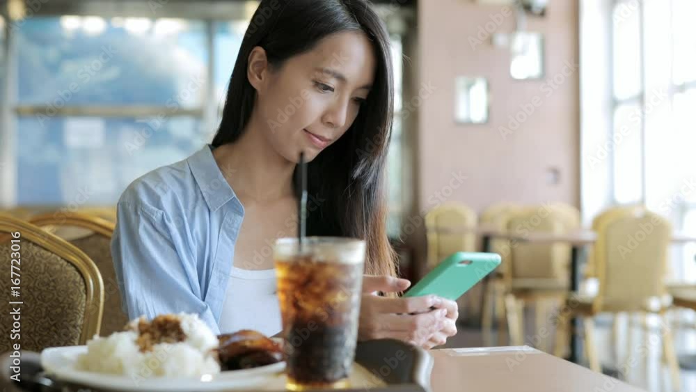 Woman use of smart phone in restaurant Woman use of smart phone in restaurant