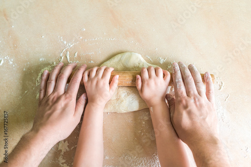 Children and dad hands rolled dough