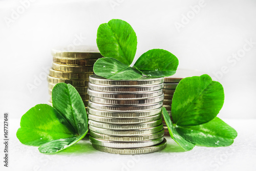 Stacks of Russian coins with clover leaves on a gray background with droplets of water. St.Patrick 's Day. photo