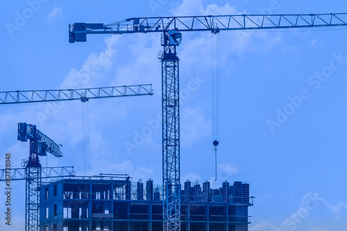 Construction cranes on a bl...