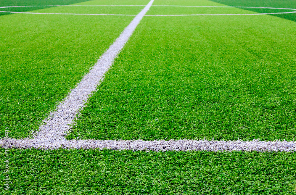 Photo of a green synthetic grass sports field with white line shot from above