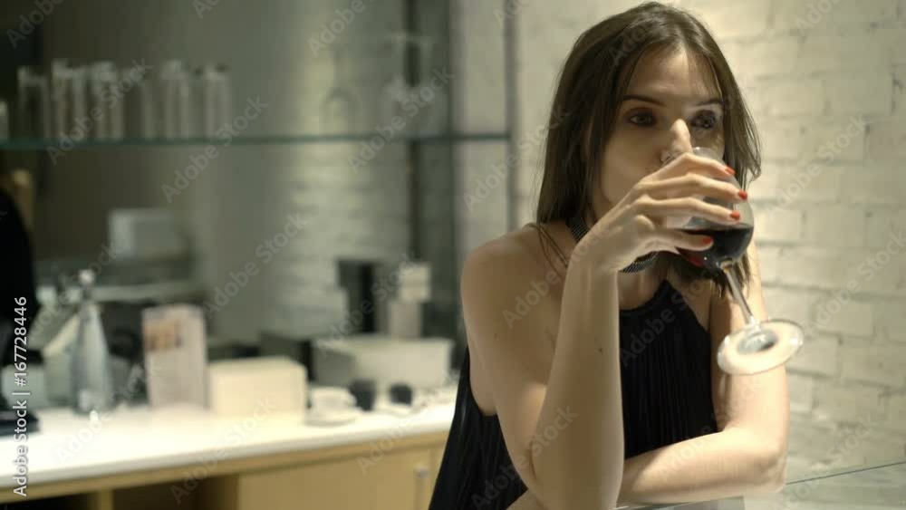Sad, unhappy woman drinking wine sitting by counter in cafe at night
Sad, unhappy woman drinking wine sitting by counter in cafe at night
