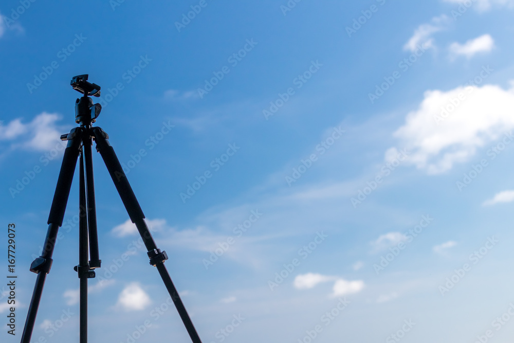 Black tripod on the tropical beach of Bali island, Indonesia. Photographer lifestyle concept. Black tripod on the tropical beach of Bali island, Indonesia. Photographer lifestyle concept.