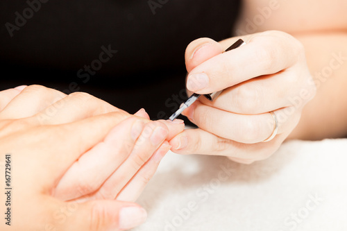 Laying nail polish on a woman s hands