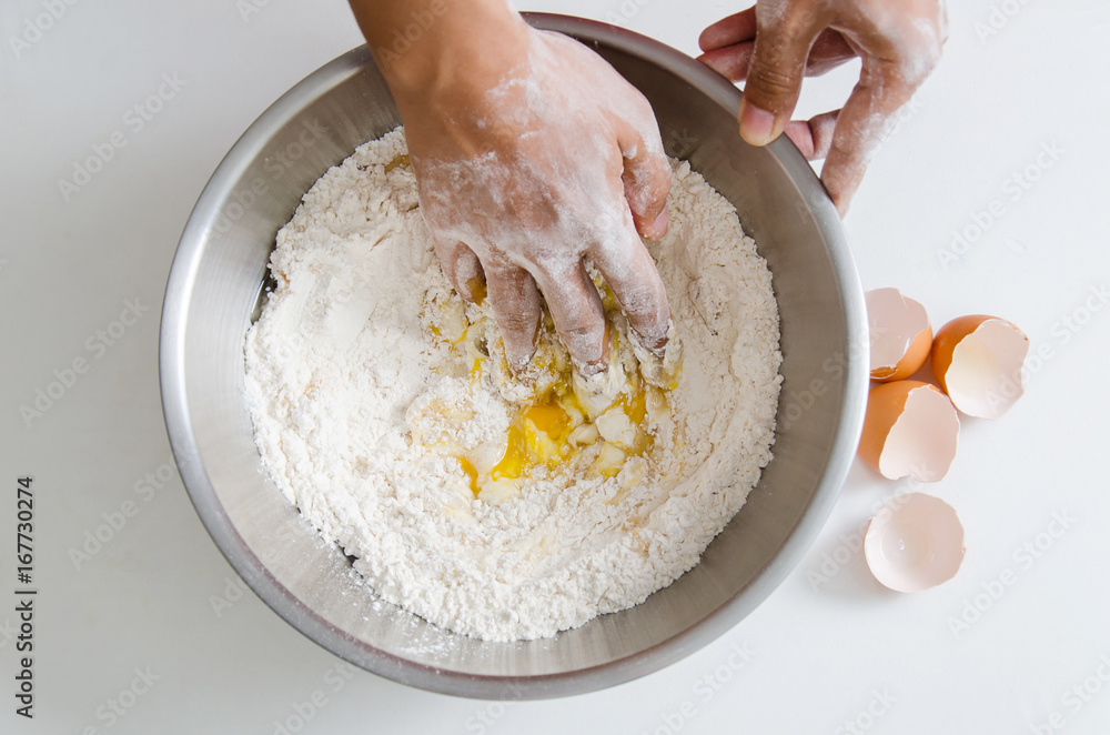 Bread cooking,hand mixing egg yolk,sugar and flour in a bowl.Homemade bakery at home Bread cooking,hand mixing egg yolk,sugar and flour in a bowl.Homemade bakery at home