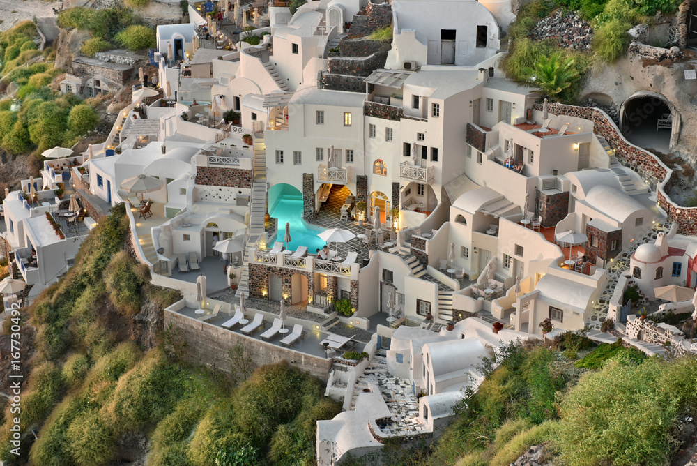 Fototapeta premium The famous Cycladic Architecture cave houses which are used as motels and inns built on cliffs in the town village of Oia, Santorini, Greece.