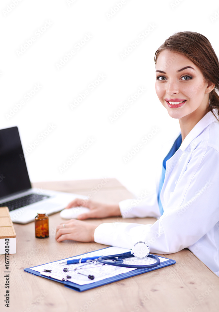 Beautiful young smiling female doctor sitting at the desk Beautiful young smiling female doctor sitting at the desk