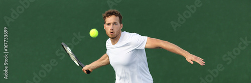 Tennis player man banner hitting ball with racket on green horizontal copy space background. Sports athlete training forehand grip technique on outdoor court. © Maridav