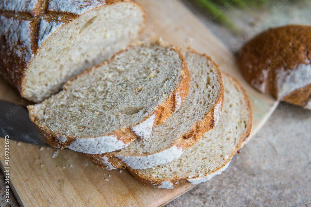 Bread slice on a wooden board. Wheat fresh loaf