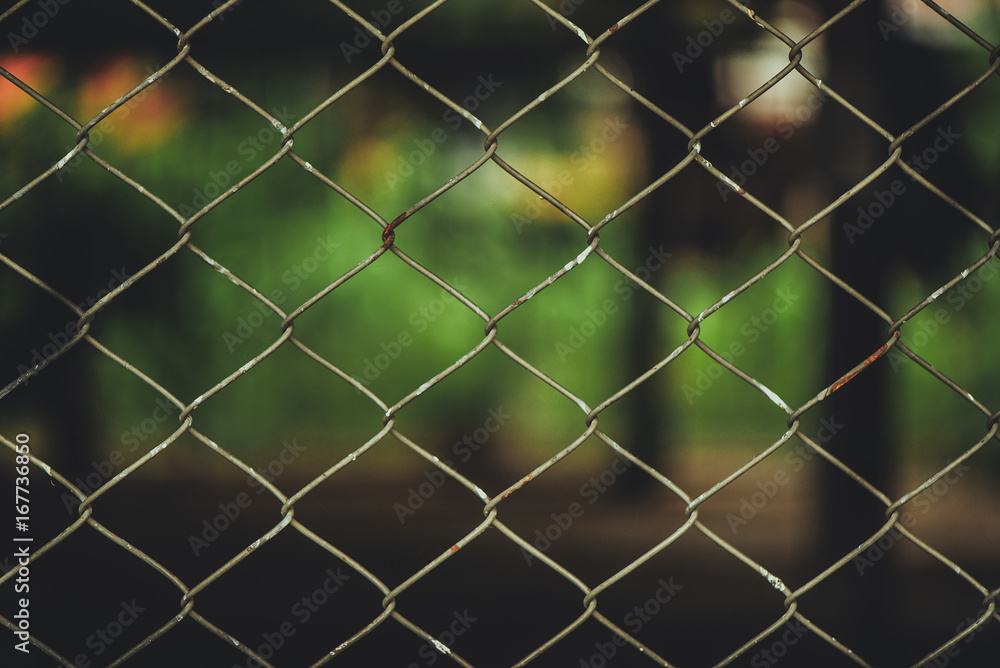 Fototapeta premium Rusty Chain Link Fence of steel netting on blur background.