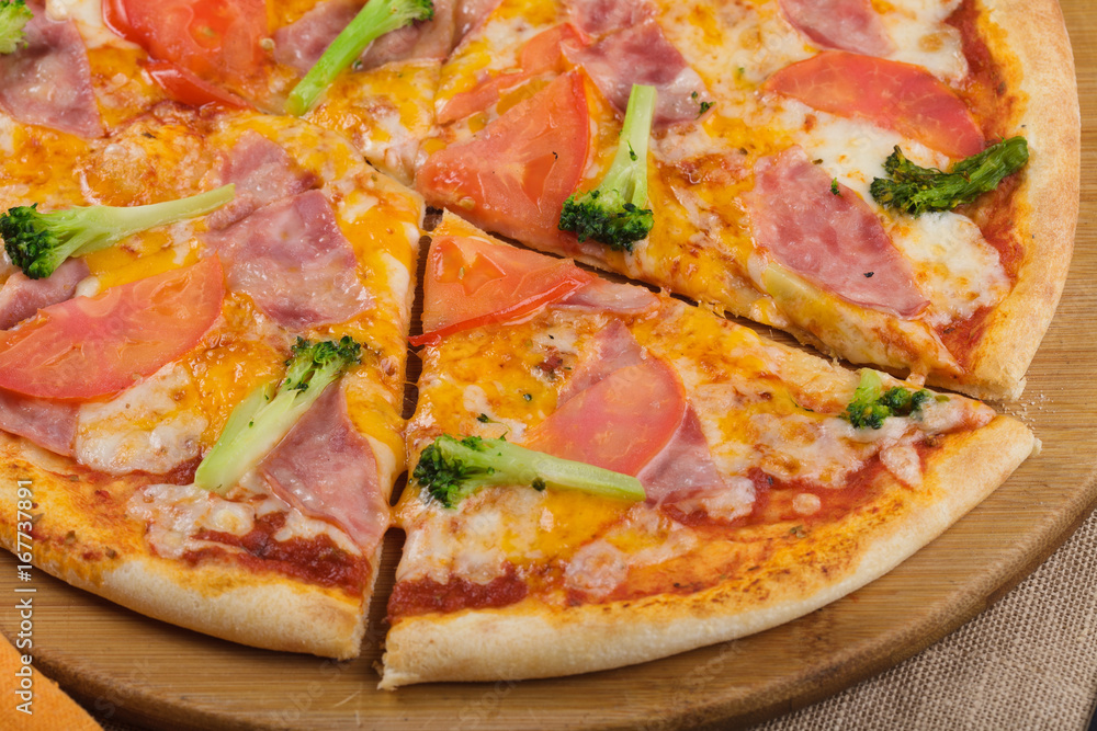 Pizza with ham, tomatoes and cheese. Close up.