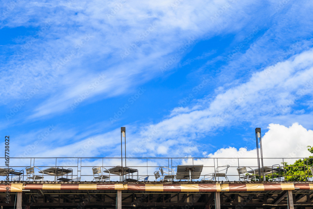 Many table and chairs on the restaurant deck against the sky. Many table and chairs on the restaurant deck against the sky.