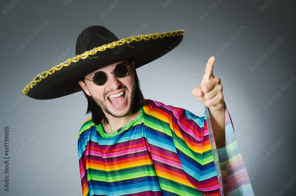 Man in a vivid mexican poncho gray background isolated Man in a vivid mexican poncho gray background isolated