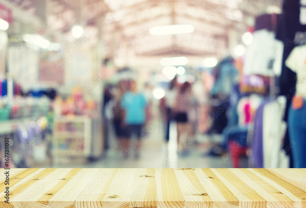 Blurred image of retail store in shopping mall montage with wood table for background. Blurred image of retail store in shopping mall montage with wood table for background.