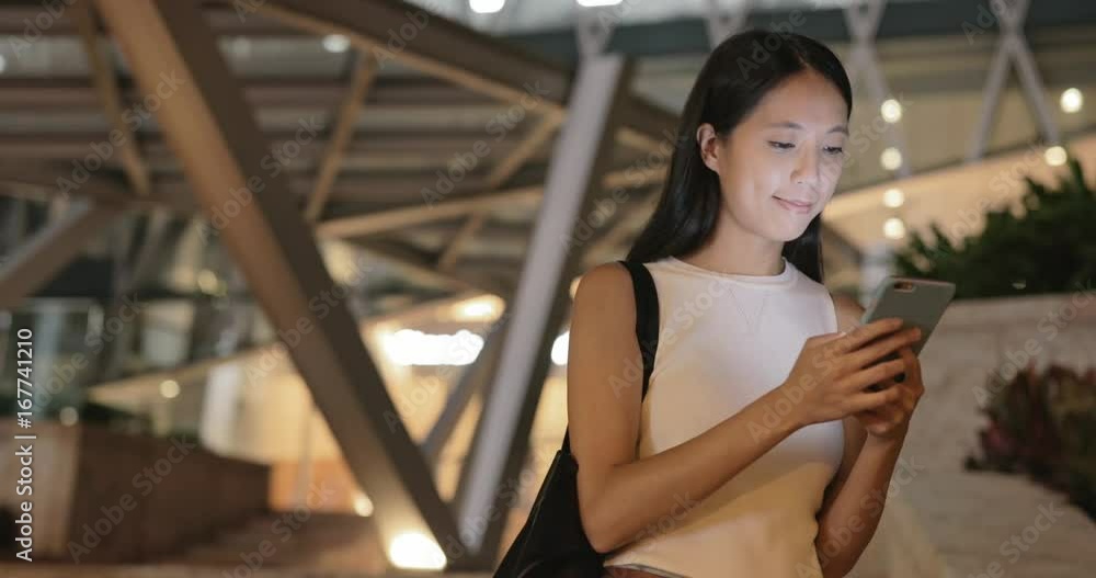 Woman sending sms on mobile phone at night Woman sending sms on mobile phone at night