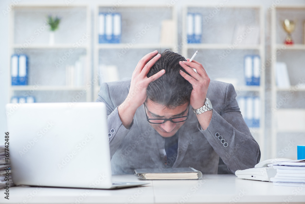 Businessman smoking in office at work Businessman smoking in office at work