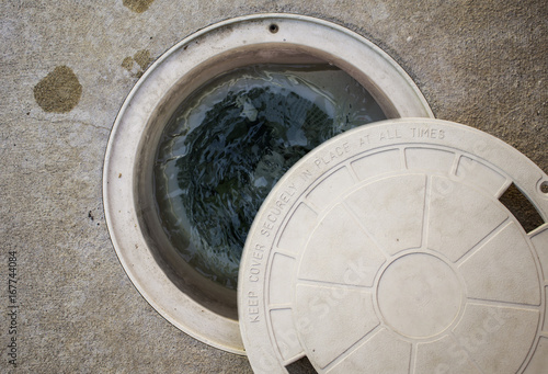 Pool filter cover open, showing swirling water.