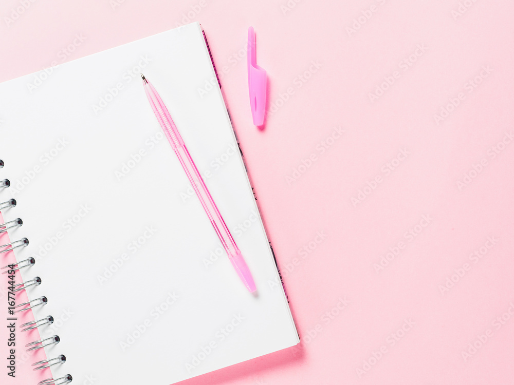 Top view of blank note paper with pen on pink pastel background. Copy ...