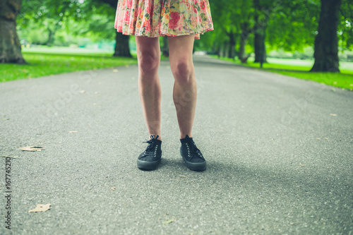 Legs of young woman walking in park