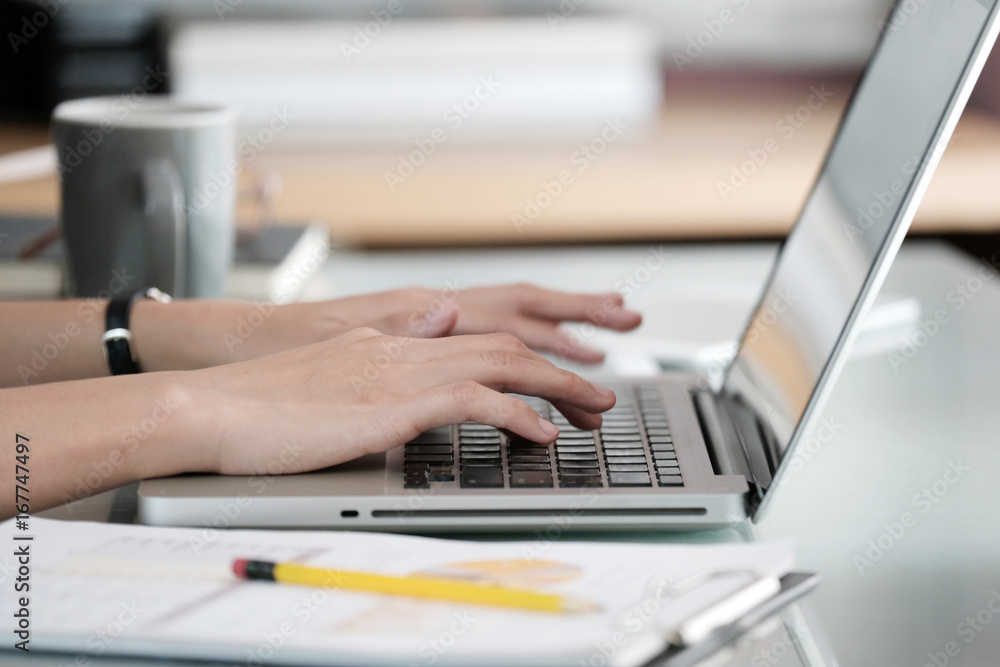 Woman hands typing laptop computer at office desk background, office lifestyle, business and technology Woman hands typing laptop computer at office desk background, office lifestyle, business and technology