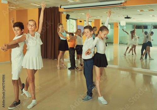 Group of children dancing tango in dance studio