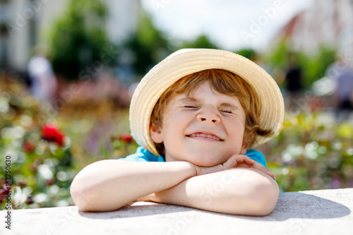 Portrait of little kid boy in hat in summer. Happy child.