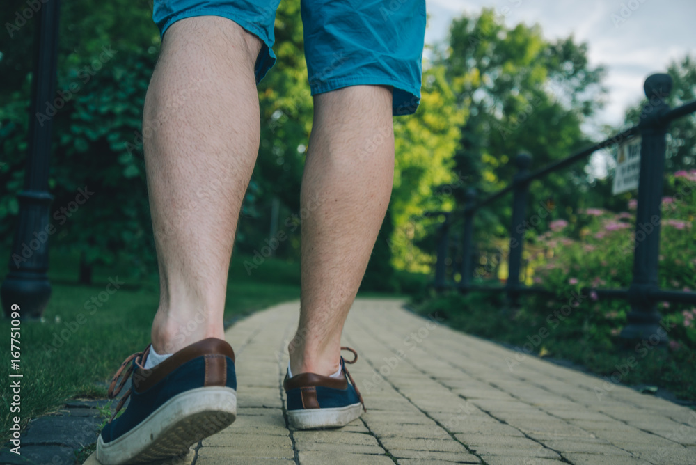 Cropped photo of young man walking in the park