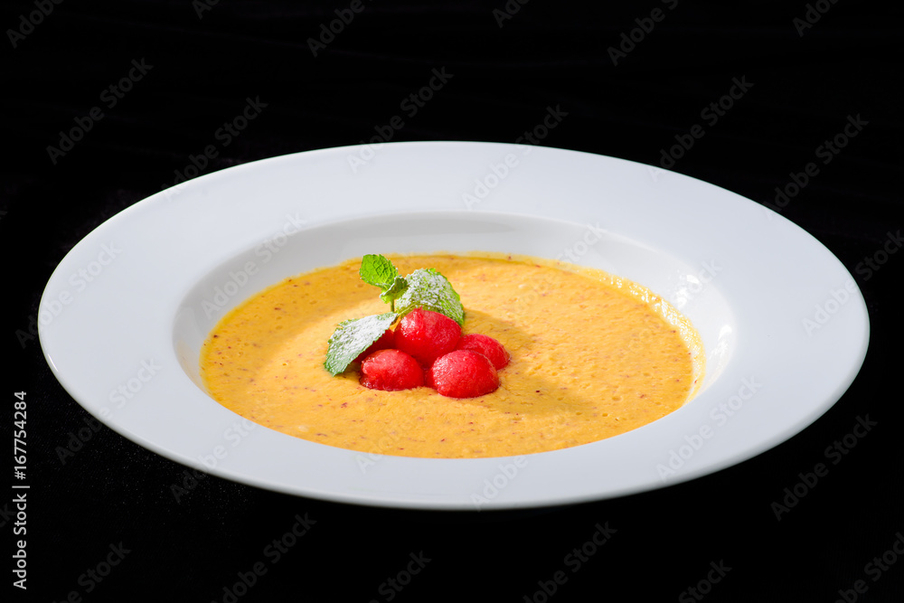 summer delicious fresh smoothie made with apricot and mango in white plate. Beautifully decorated dish, dark background summer delicious fresh smoothie made with apricot and mango in white plate. Beautifully decorated dish, dark background