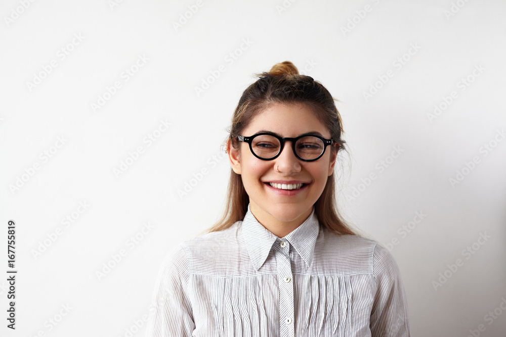 Attractive successful cute young businesswoman wearing formal clothing and eyeglasses having happy cheerful look after she made good deal, rejoicing at her success. People and business concept