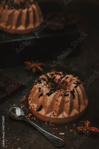 Italian dessert. Panna cotta on dark chocolate, with a chocolate crock and chocolate sprinkles on a dark background