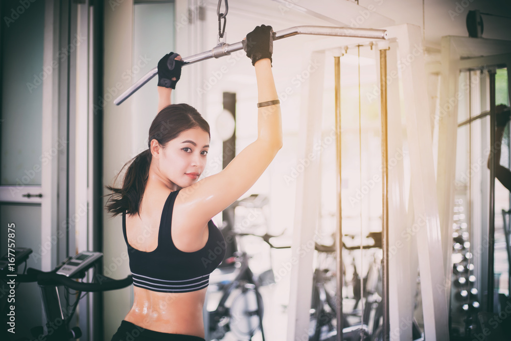 Fototapeta premium beautiful muscular fit woman exercising building muscles and fitness woman doing exercises in the gym. Fitness - concept of healthy lifestyle,soft focus
