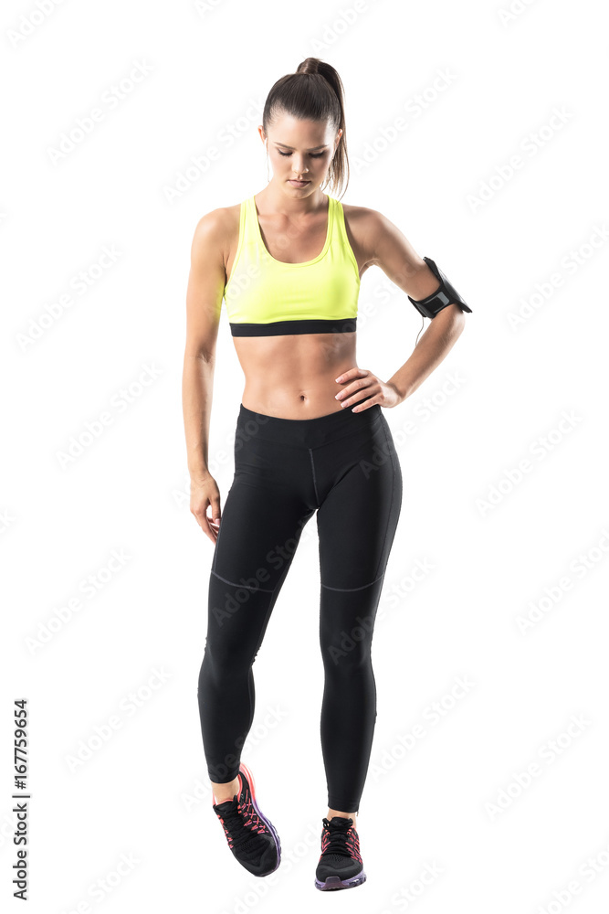 Athletic fit female jogger warming up with foot ankle rotation exercise. Full body length portrait isolated on white studio background Athletic fit female jogger warming up with foot ankle rotation exercise. Full body length portrait isolated on white studio background